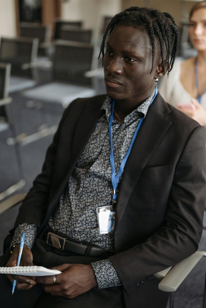 Businessman in a formal meeting, attentively taking notes with a notebook in hand.